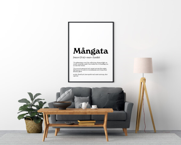 A framed art print featuring the Swedish word "Mångata" in bold text. The definition describes it as "The glistening, road-like reflection of moonlight on water, creating a path that looks like it’s leading you across the waves," with a dreamy and romantic tone.