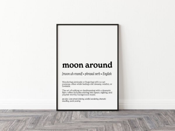 A minimalist print displaying the phrase "moon around" with its pronunciation and definition: "Wandering aimlessly or lingering with no set purpose, often while feeling a bit dreamy, wistful, or lovesick." A playful explanation suggests it includes "staring into space, sighing, and playlist-worthy background music."